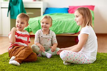 Image showing group of happy kids sitting on floor at home