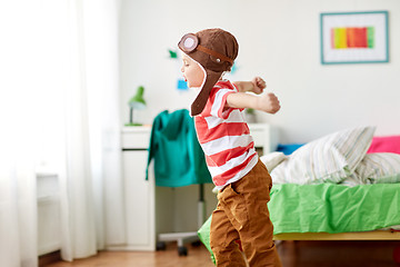 Image showing happy little boy in pilot hat playing at home