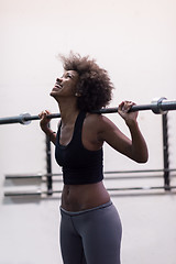 Image showing black woman lifting empty bar