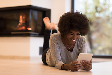 Image showing black women using tablet computer on the floor