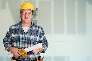 Image showing Contractor with Plans and Hard Hat In Front of Drywall.