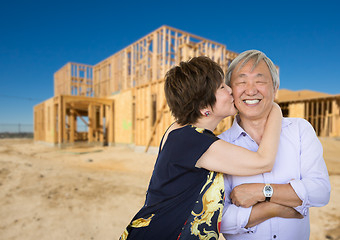Image showing Chinese Senior Adult Couple Kissing In Front Of New House Framin