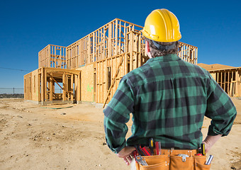Image showing Contractor with Hard Hat Looking At New House Framing at Constru