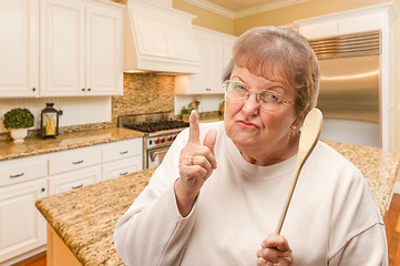 Image showing Senior Adult Woman Scolding with The Wooden Spoon Inside Kitchen