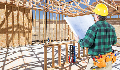 Image showing Contractor with hard Hat and Plans Standing Inside Construction 