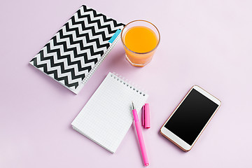 Image showing The top view on female desk. The phone and french macarons on trendy pink desk.