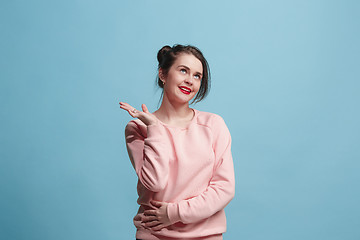 Image showing The happy business woman standing and smiling against blue background.