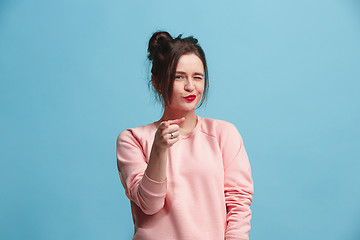 Image showing The happy business woman point you and want you, half length closeup portrait on blue background.