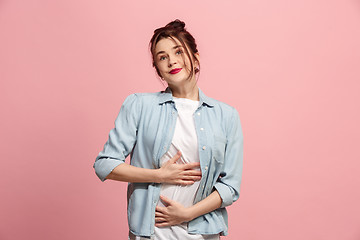 Image showing The happy business woman standing and smiling against pink background.