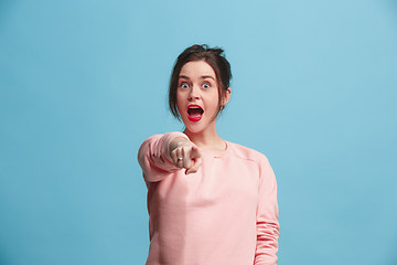 Image showing The happy business woman point you and want you, half length closeup portrait on blue background.