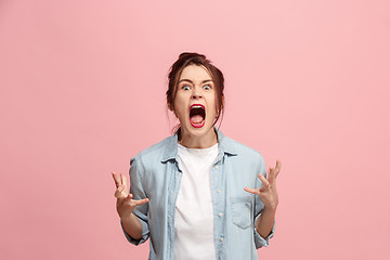 Image showing The young emotional angry woman screaming on pink studio background