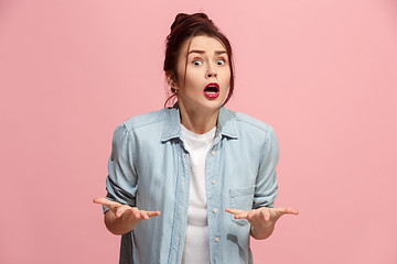 Image showing Beautiful female half-length portrait isolated on pink studio backgroud. The young emotional surprised woman