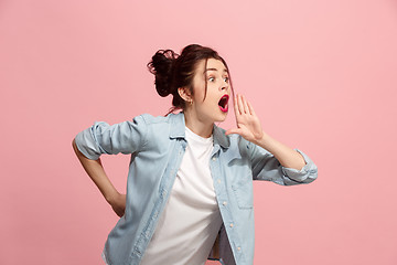 Image showing Isolated on pink young casual woman shouting at studio