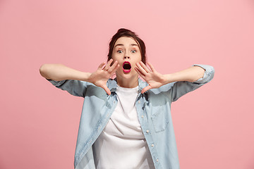 Image showing Isolated on pink young casual woman shouting at studio