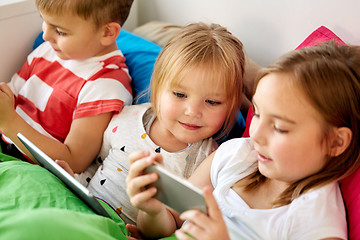 Image showing little kids with smartphone in bed at home