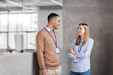 Image showing man and woman with conference badges at office