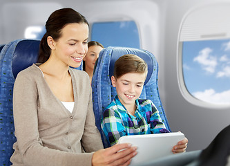 Image showing happy family with tablet pc sitting in plane