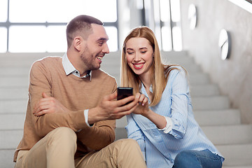 Image showing man and woman with smartphone at office stairs