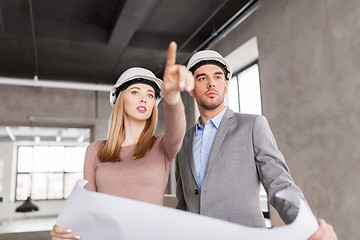 Image showing architects with blueprint and helmets at office