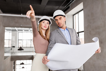 Image showing architects with blueprint and helmets at office