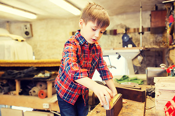 Image showing happy little boy with plank and ruler at workshop