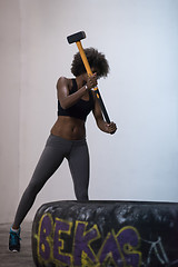 Image showing black woman workout with hammer and tractor tire