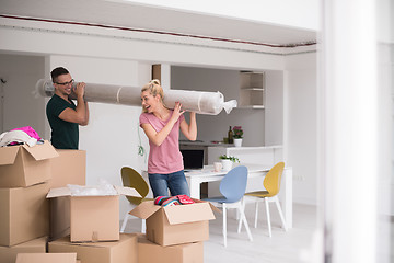 Image showing couple carrying a carpet moving in to new home