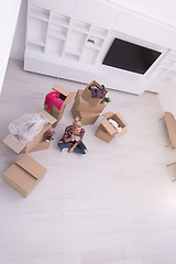 Image showing woman with many cardboard boxes sitting on floor