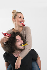 Image showing couple in party hats blowing in whistle