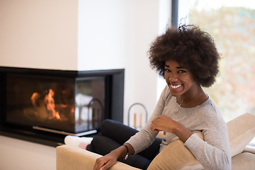 Image showing black woman in front of fireplace