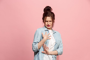Image showing Young woman with disgusted expression repulsing something, isolated on the pink
