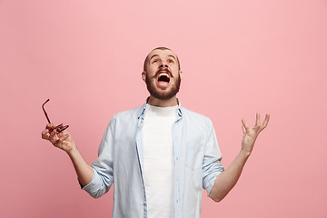 Image showing The young emotional angry man screaming on pink studio background