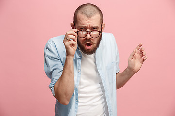 Image showing Suspiciont. Doubtful pensive man with thoughtful expression making choice against pink background