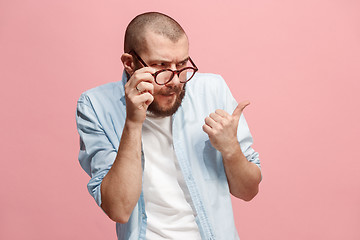 Image showing Suspiciont. Doubtful pensive man with thoughtful expression making choice against pink background