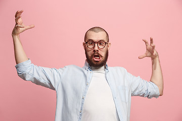 Image showing Portrait of an angry man looking at camera isolated on a pink background