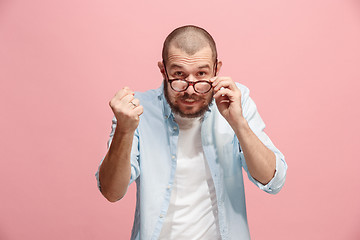 Image showing Portrait of an angry man looking at camera isolated on a pink background