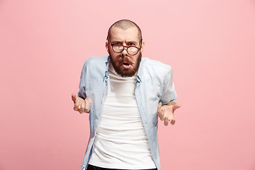 Image showing Portrait of an angry man looking at camera isolated on a pink background