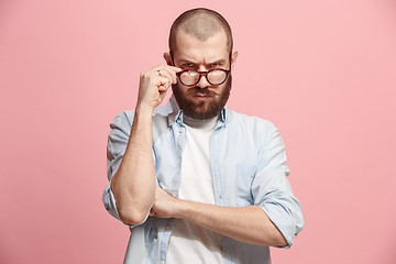 Image showing Suspiciont. Doubtful man with thoughtful expression making choice against pink background