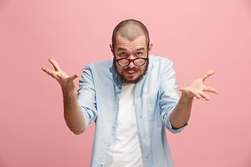 Image showing Beautiful male half-length portrait isolated on pink studio backgroud. The young emotional surprised man