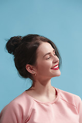 Image showing The happy business woman standing and smiling against blue background.