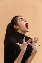 Image showing The young emotional angry woman screaming on pastel studio background