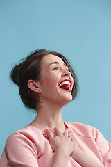 Image showing The happy business woman standing and smiling against blue background.