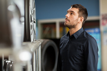 Image showing male customer choosing wheel rims at car service