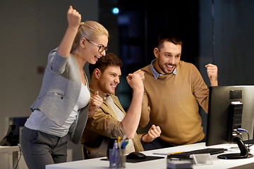 Image showing business team celebrating success at night office