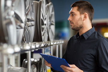 Image showing auto business owner and wheel rims at car service