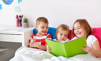 Image showing little kids reading book in bed at home