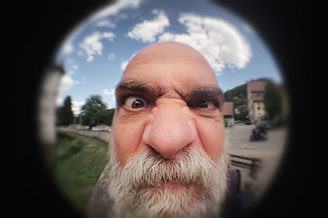 Image showing an angry man looking to a peephole door