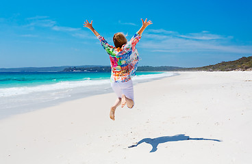 Image showing Summertime woman jump for joy beach