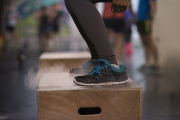 Image showing black woman is performing box jumps at gym