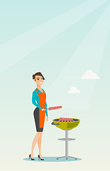 Image showing Woman cooking steak on barbecue grill.